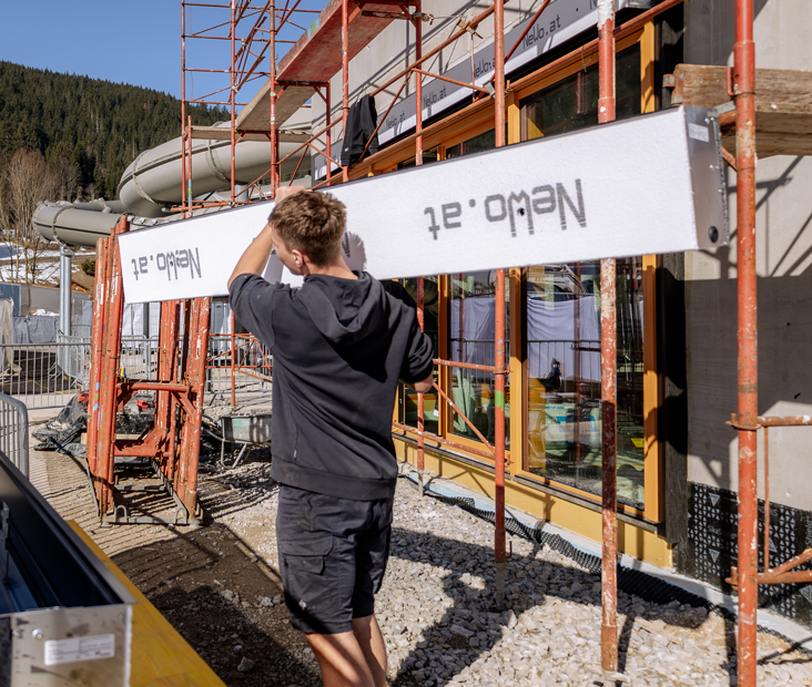 Monteur installiert Rollladen bei Schachtmontage im Neubau auf Baustelle